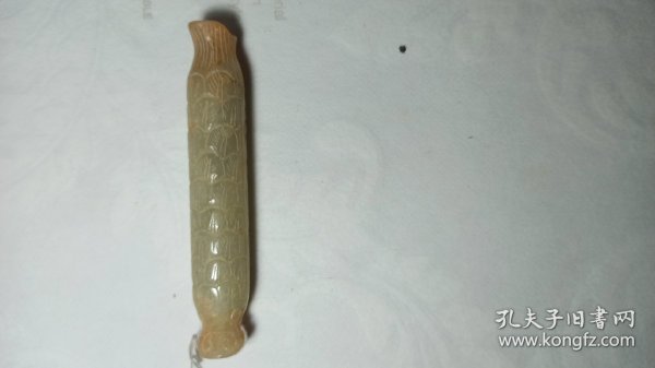 白玉巧雕怪鱼，背上鳞片如羽毛状，肚上鳞片如阶梯。怒目圆睁，张着血盆大囗，似乎在捕食