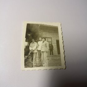 老照片–三名女子站在院子里留影（身后老房子窗前有一个女人）