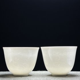 甜白釉暗刻龙凤纹杯子。