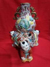 [旧藏珍罕器型 广彩瓷器 ] 建国初期五十年代三童足“百花不落地″重彩描金堆塑九龙纹双耳葫芦瓶~《三宝送福，童子献福》金彩福瓶。此瓶造型及工艺繁复 人物开脸自然，葫芦是吉祥之物。寓意福寿延年，福祥吉庆之意。 罕有之物，可赏可藏 (高28厘米)