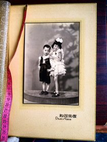 民国时期二位穿着西式裙子和服装的小朋友合影，蝶求照相馆。