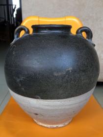 唐代黑釉双系大罐，高22厘米、口径8.5厘米、底足径9.5厘米。罐腹部有一处窑粘