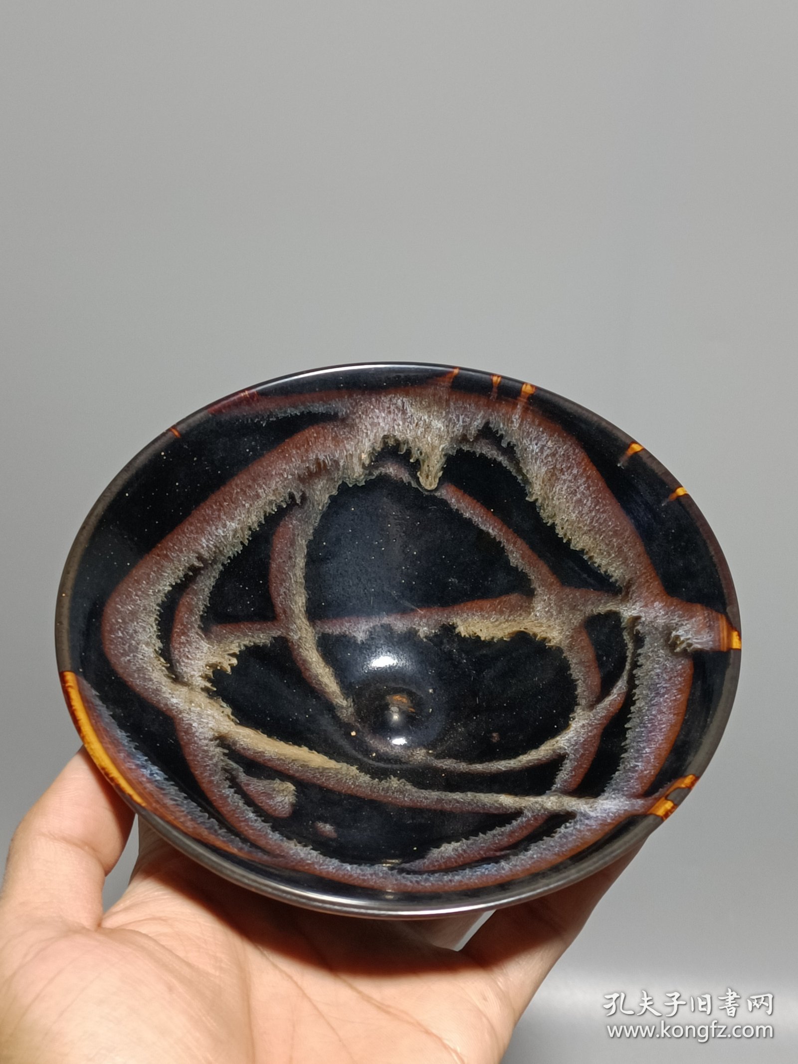 宋代吉州窑洒釉斗笠碗，窑变釉色，黑釉底色配红褐斑纹，釉面自然窑变，线条流畅。碗型规整，胎质细腻，底部干练，整体保存不错，无明显磕碰，品相以图为准。尺寸：直径15.6cm，高5.4cm。适合收藏或茶道使用。