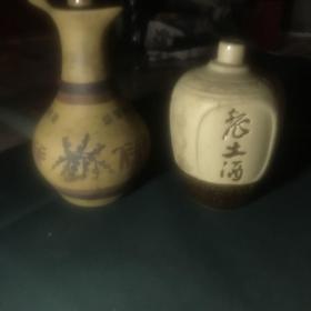 老酒瓶两个收藏——（1）老土酒陶瓷酒瓶一个，（2）迎驾贡酒陶瓷画彩酒瓶一个，共计两个，其中一个酒瓶嘴处有一缺口，余好！（客厅酒瓶柜下面）