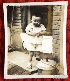 可爱的小男孩在老屋门前看着锅害怕的样子老照片