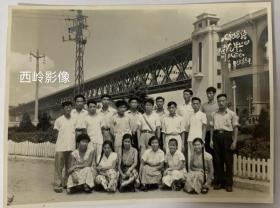 【老照片】北京俄语学院毕业四川队（毕业生）1958年8月留念 （背景应为武汉长江大桥）— 校简史：1949年北京俄文专修学校成立，由中央编译局的正副局长师哲、张锡俦兼任正副校长。1951年2月，北京外国语学校俄文部并入北京俄文专修学校；1955年6月，北京俄文专修学校改为北京俄语学院；1959年2月，北京俄语学院并入北京外国语学院；现为：北京外国语大学俄语学院。— 稀见教育影像史料～