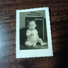 老照片–可爱小宝宝坐在桌子上留影（身后有一本大书）