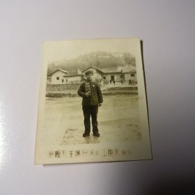 老照片–戴眼镜青年手拿红宝书在韶山毛主席故居前留影（1969年，身后故居和游客清晰可见）