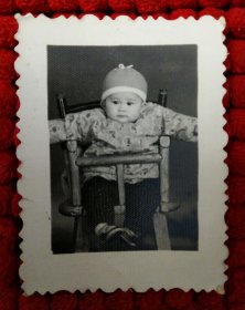 坐宝宝椅子的小男孩 老照片