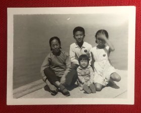 老太太和戴毛主席像章的三名儿童在海边留影老照片