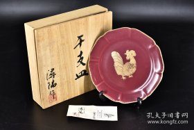 日本《干支陶器皿》原木盒一件 带支架 传统工艺陶瓷器 金边 生肖鸡 盘内金鸡图案 花瓣形边沿 尺寸：21.6*21.6cm 高：2.6cm 日本陶瓷器的发展自应永年到昭和共经历了500多年的历史，行业在不断地发展，技术在不断地进步，有的已经达到了很高的水平。