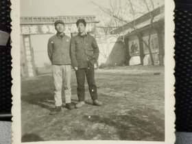 建国初期工人在厂门口(墙上宣传画保卫祖国，厂门上有横幅标语，时代特征明显)