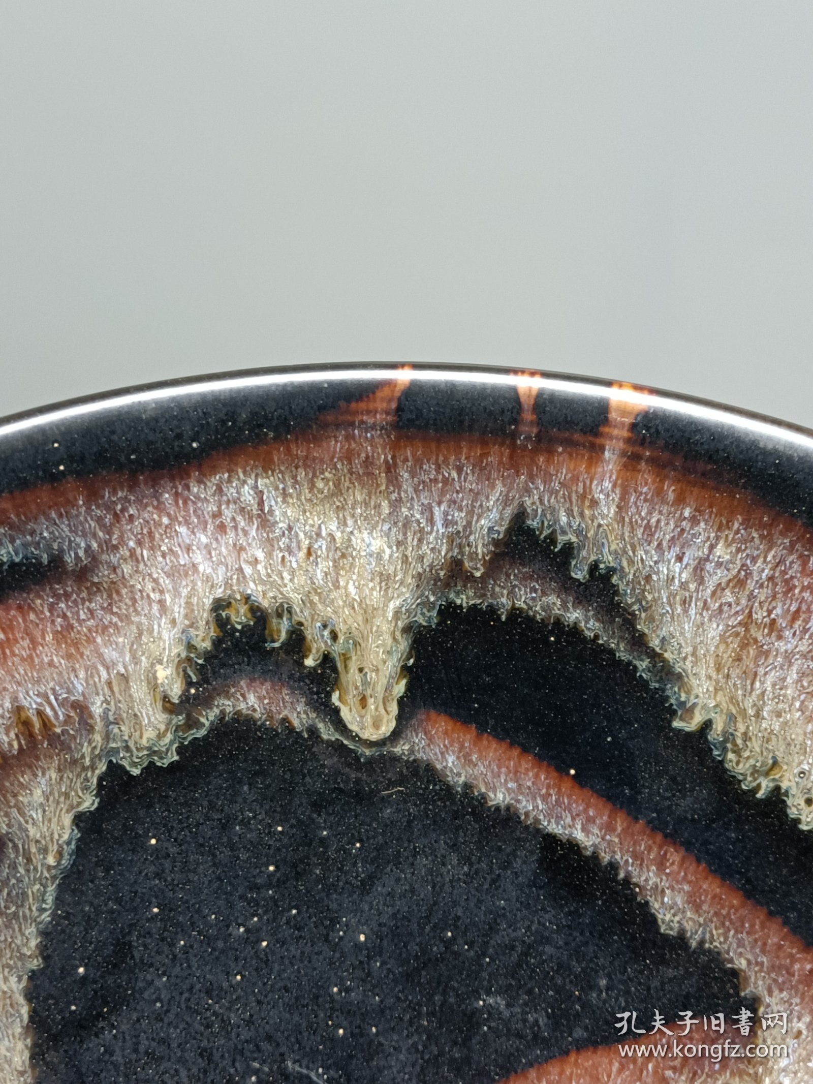 宋代吉州窑洒釉斗笠碗，窑变釉色，黑釉底色配红褐斑纹，釉面自然窑变，线条流畅。碗型规整，胎质细腻，底部干练，整体保存不错，无明显磕碰，品相以图为准。尺寸：直径15.6cm，高5.4cm。适合收藏或茶道使用。