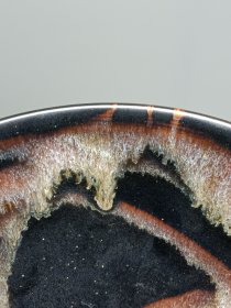 宋代吉州窑洒釉斗笠碗，窑变釉色，黑釉底色配红褐斑纹，釉面自然窑变，线条流畅。碗型规整，胎质细腻，底部干练，整体保存不错，无明显磕碰，品相以图为准。尺寸：直径15.6cm，高5.4cm。适合收藏或茶道使用。