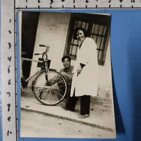 精品自行车老照片（曾经是家庭一大件，十分爱惜。男的擦车，女的打气）