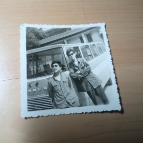 老照片–两个帅气青年站在老式客车旁留影