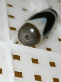 老台一达洛虎牙天珠，手工打磨，两端粗细不匀以及珠体都不正圆，包浆油润细腻温润，孔道压缩明显，皮下可见小密集风化纹，整体珠子还不错，有缘者恭请吧！