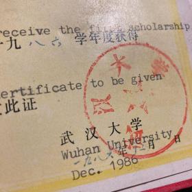 武汉大学人民奖学金证书三个，红色绸面烫金，都有霉渍