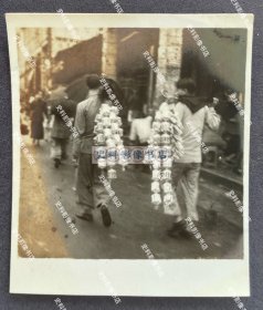 【广州旧影】1940年 广州沿街集市上两青年用伞柄挑着售卖的纯手工编织的蝈蝈笼子 原版老照片一枚（背面有1940年8月12日“广州中央宪兵分队”检阅章）