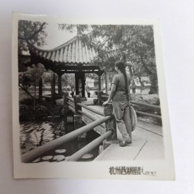 梳着长长的麻花辫拿着斗笠的美女在杭州西湖三潭映月留影照片。