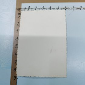 老照片：一位男士在武汉中山公园留影、背景是：“张公亭”廊柱上悬挂“伟大的中国共产党万岁、世界人民大团结万岁”布标、尺寸：6×8.5cm