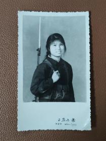 老照片：万县市照相馆里拍摄的女农兵背枪和弹夹的黑白照片     有1张售    文件盒七