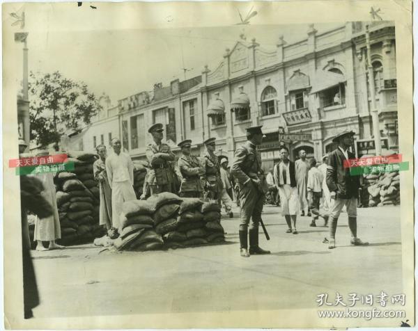 1928年6月国民党北伐军打下天津，驻扎在天津的美军巴特勒将军，在街头堡垒工事前，密切关注冯玉祥部的动态。这张照片恰巧拍摄下了中国摄影史上的近代著名照相馆天津鼎章照相馆的门店，也可见天盛号酱肘等商铺、