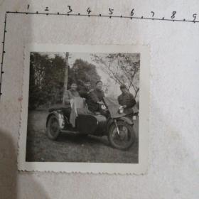 三青年骑三轮摩托车照（旁边有一军人）