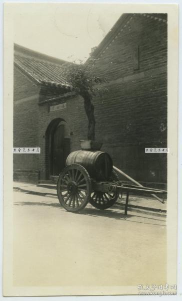 民国时期街头小巷中停放的送水车老照片，旁边门洞的名称可能是“福禄里”