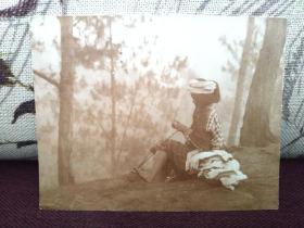 【民国时期 台湾土著高山族少女，在晨曦中的林地间，极美人像摄影老照片，12X9.4厘米】（背面有英文说明“mending woman”，即“织补中的女人”的意思。）