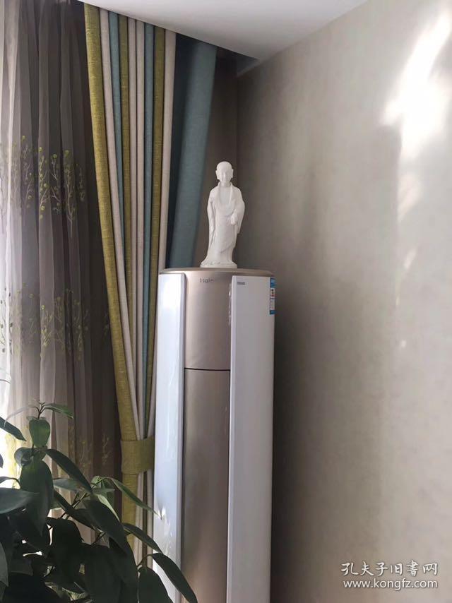 白瓷微笑小佛陀，家居装饰佳品，带包装 此艺术品为白瓷，瓷雕表面白洁如玉，衬托以小沙弥佛性的微笑，佛陀面部刻画俊朗，面部轮廓甜美，俊雅，展现东方式的迷人微笑，渡人向善，让欣赏者心灵受到净化变得安静纯净。尺寸高约35cm，肩宽约11cm。