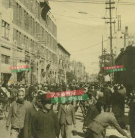 民国1945年左右天津和平路人流熙攘的街道，可见远处中原公司的尖顶，新兴洋服店女子服装专家等招牌。泛银