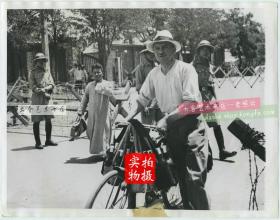 1939年爱国抗日志士在天津英租界成功刺杀了--亲日派的新任天津海关监督兼伪华北联合准备银行天津支行经理程锡庚，“程锡庚事件”后日军封锁英法租界，照片中一外籍送奶工被迫使用自行车运载小瓶奶前往英租界。附近有天津警察。