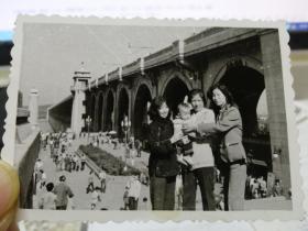 【老黑白照片（相片）】约八十年代 武汉长江大桥合影（一个中老年妇女抱小孩 两个时髦美女在两边）8.5*6cm