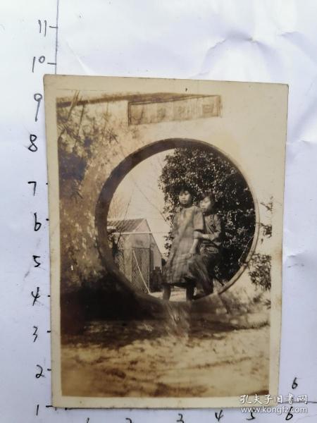 民国老照片：两个穿旗袍女孩在圆形的门前 留影