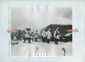 1951年朝鲜战争中联合国军士兵在朝鲜原州市一带穿着白色伪装防寒服在雪地中行军老照片。