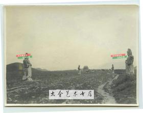 1913年7月北京昌平明十三陵神路老照片，路边依次排列着文官武官神兽等石雕，远处的建筑是碑楼