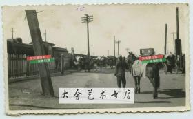 民国时期天津火车站外的街道，可见等客人的人力车以及牵马的马夫老照片