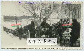 民国时期冬季的天津雪野中，天津百姓艰难地拉车爬坡老照片