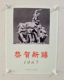 **恭贺新禧宣传画一张，中国国际书店1967年出版发行，封面雕塑作品：《庆丰收组雕》（原名：《人民公社万岁》），工农兵创作，创作于1958年11月，作品落成于北京全国农业展览馆广场。工农兵庆丰收骑马上打鼓。