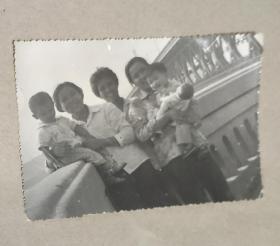 黑白照片:持冲锋枪小孩和抱小孩妇女在武汉长江大桥上合影
