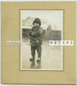 1937年左右在江苏或安徽一带的桥上，一名男童通手伫立在小雪中老照片，注意桥上的石狮子。