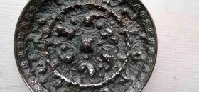 一面海兽葡萄大铜镜，直径近17厘米，厚约1厘米，重1.2公斤。特别之处是葡萄藤穿过内圈，呈缠绕状态，这样的图案是不多见的。