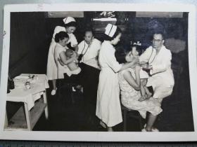 解放初52年代：上海某医院儿科 两名医师为小孩诊病老照片1张